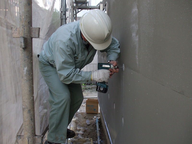 ・断熱材の固定作業 厚さ50mmのEPSを隙間なく張り付け、室内側では柱・間柱の間にグラスウール断熱材を充填する複合断熱手法で、熱抵抗値3.40（m2・K)Wと国内最高基準の断熱性能を確保。