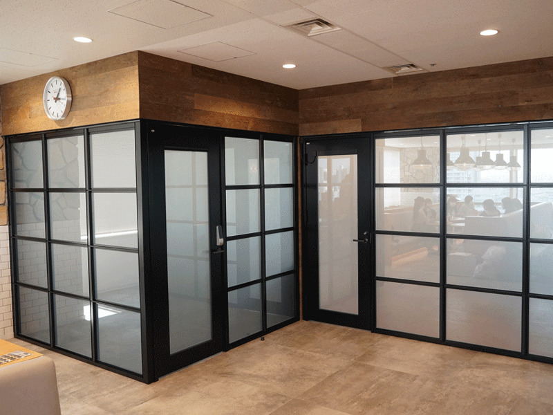 調光フィルムを既設の格子パーテーションへ施工した事例。フリーアドレスのオフィス空間に、ブラックのパーテーションが映えるオフィス。