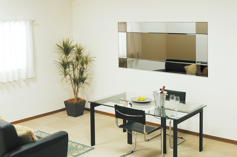 ブロンズミラーを貼ることで、映り込みを抑えながらも壁面に広がりと華やぎを感じさせるモダンなリビング、シックなインテリアに最適。