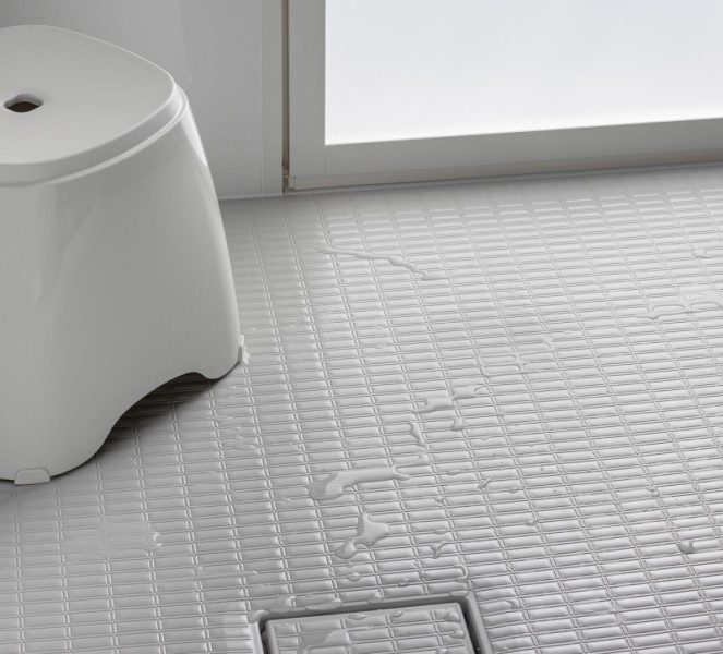 傷つきにくく、汚れが残りにくい「うつくしフロアW(ダブル)」。ダブルの溝構造が水や汚れを排水溝方向にしっかり流し、みずはけがよく乾きやすい。また、フロア表面の凹凸が足裏にフィットして滑りにくい形状。