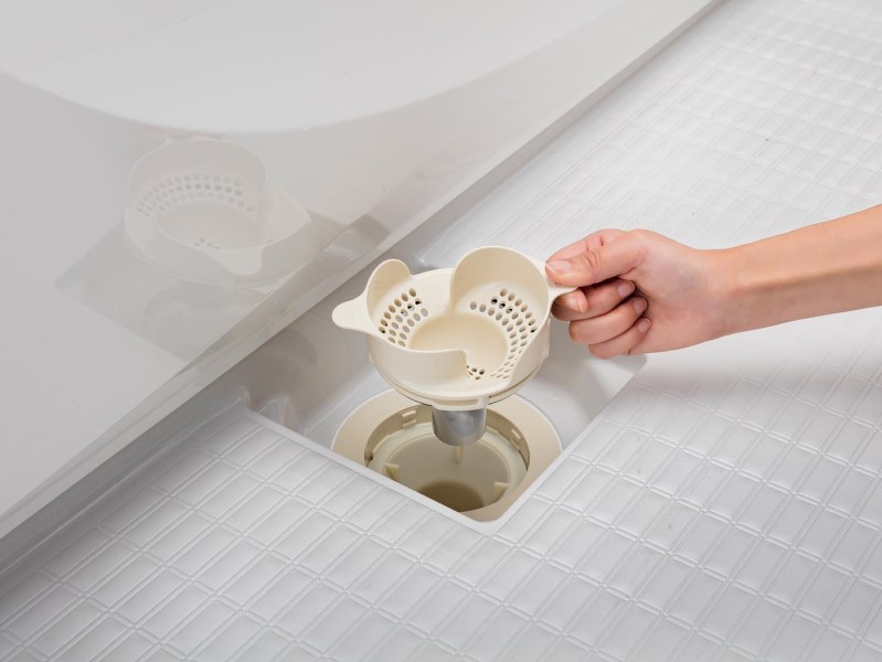 「カミトリ名人+(プラス)」。シャワーの水で髪の毛をくるっとひとまとめ、ゴミに触れずにゴミ箱へ。抗菌アタッチメント付きなので、ヌメリや臭いの原因となる菌の発生を制御し、面倒な手入れの階数を軽減。